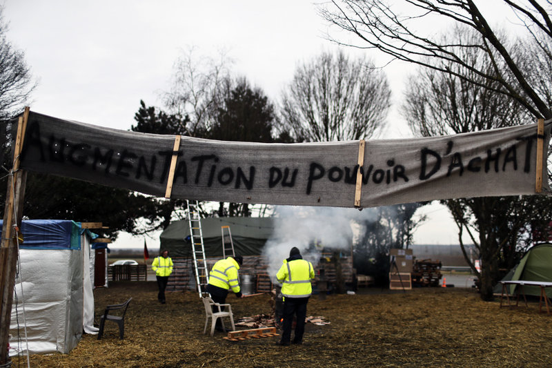 'Ökning av köpkraften', lyder banderollen vid ett tältläger uppsatt av Gula västarna-demonstranter norr om Paris, i januari 2019.