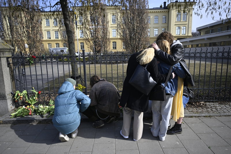 Utanför skolan har människor samlats för att hedra offren och möta varandra i sorgen.