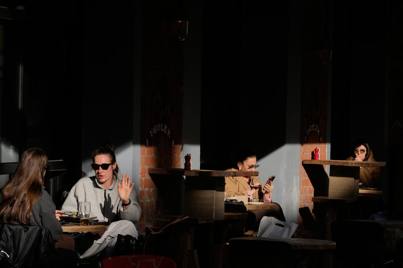 Människor på en uteservering i solen i Moskva den 13 april.