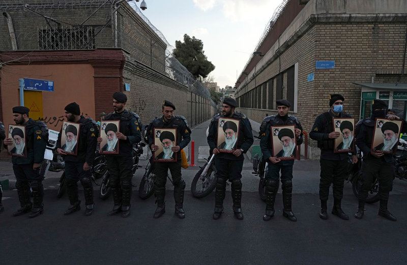 Iranska poliser håller bilder av landets högste ledare ayatolla Ali Khamenei i Teheran den 8 januari.