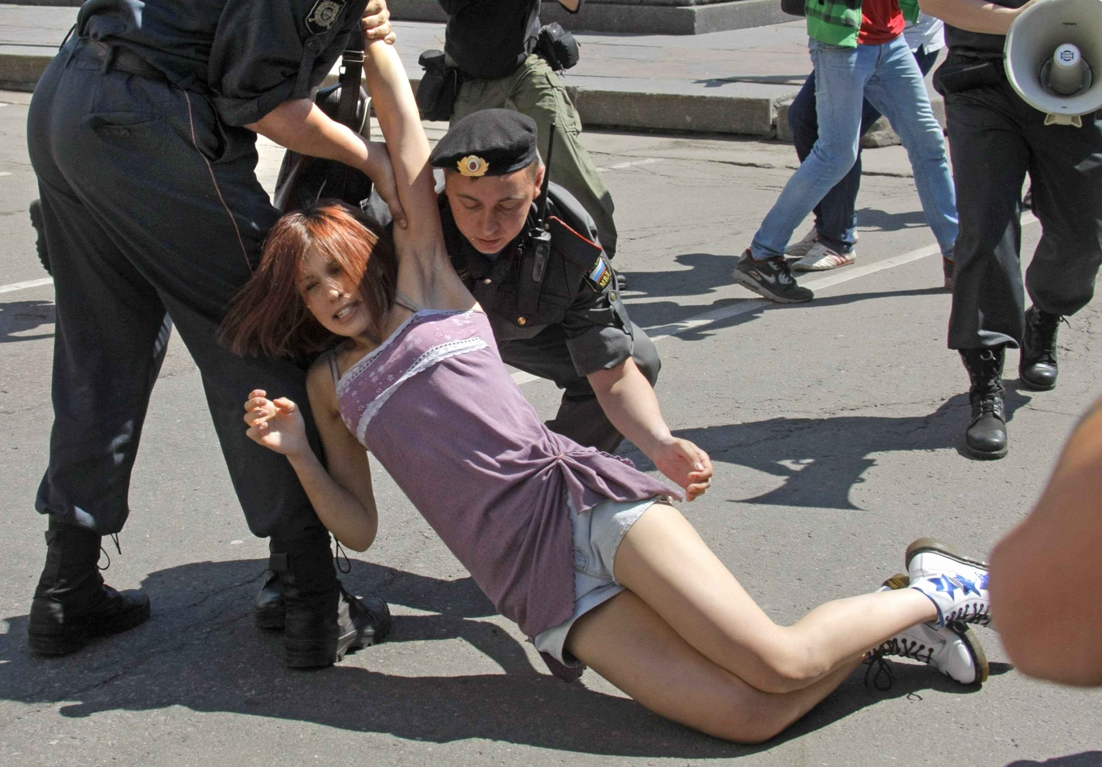 En kvinna grips under en manifestation.