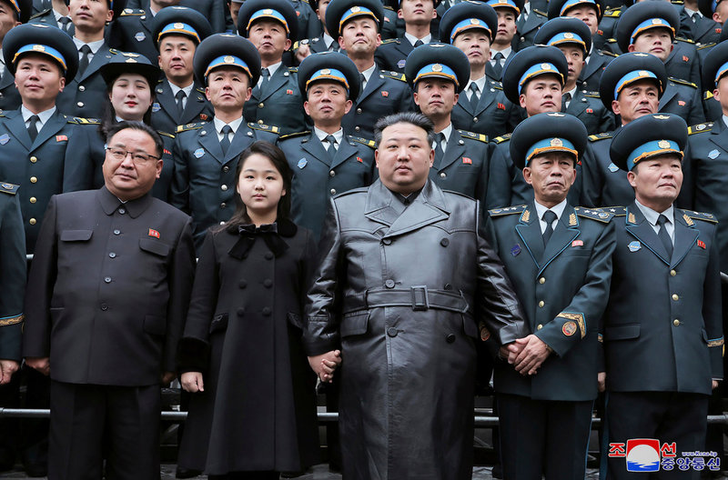 Far och dotter Kim poserar för en gruppbild efter uppskjutningen av en spionsatellit i Pyongyang 2023. Bilden har distribuerats genom Nordkoreas statliga medier.