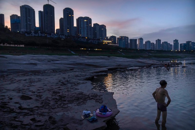 Elfartygen ingår i satsningar för att göra Yangtze-floden renare. Här svalkar sig en man i flodens utkanter under förra årets varma sommar.