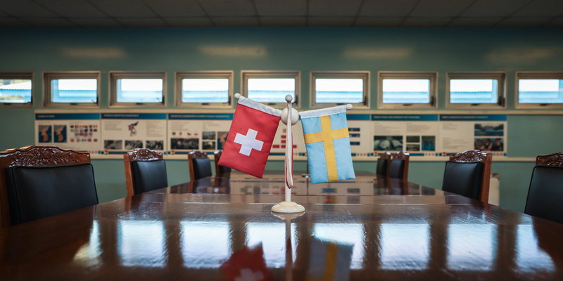 Genom åren som gått har färgen på den svenska flaggan bleknat, men den vajar stadigt bredvid Schweiz flagga.