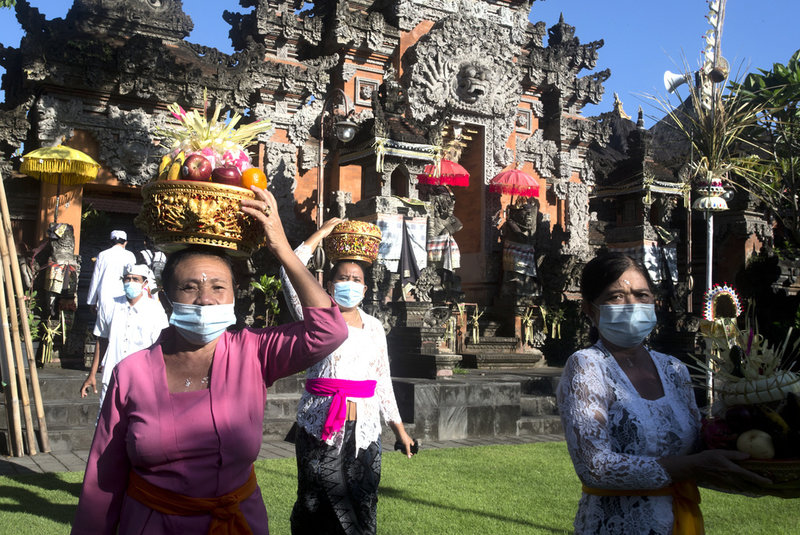 En religiös högtid vid ett hinduiskt tempel på Bali. Templet på bilden är inte Uluwatu.