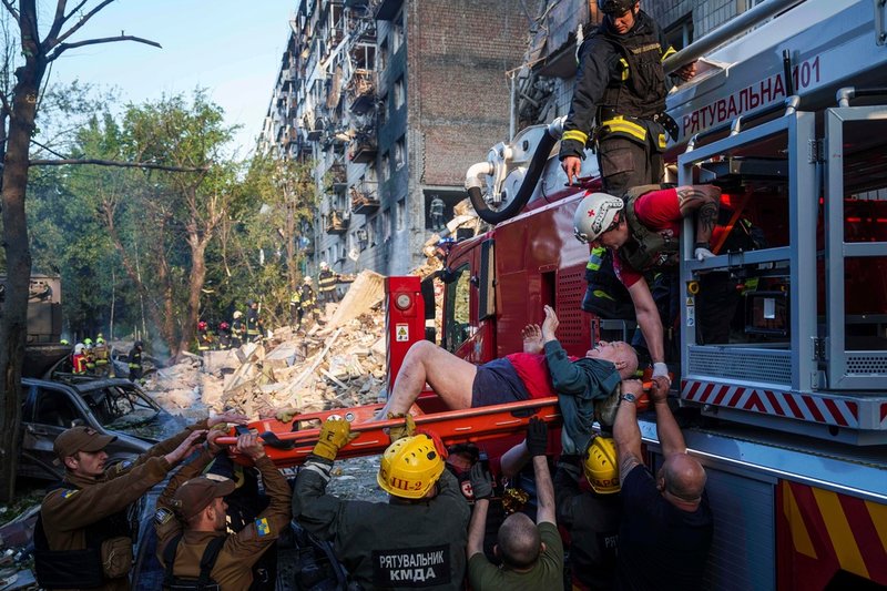 En skadad man evakueras från ett flervåningshus i Kiev på tisdagen.