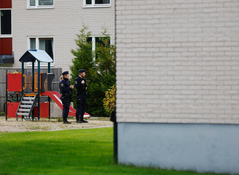 Polis på plats utanför huset i Harmånger där ambulanssjukvårdaren mördades i tjänsten.