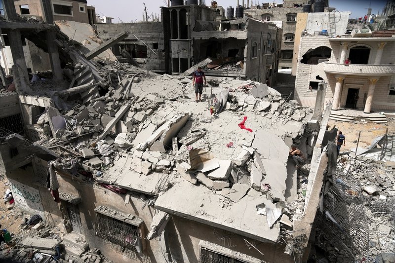 Människor inspekterar det som kvarstår av familjens Jabrs hus i Jabalia i norra Gaza på söndagen.