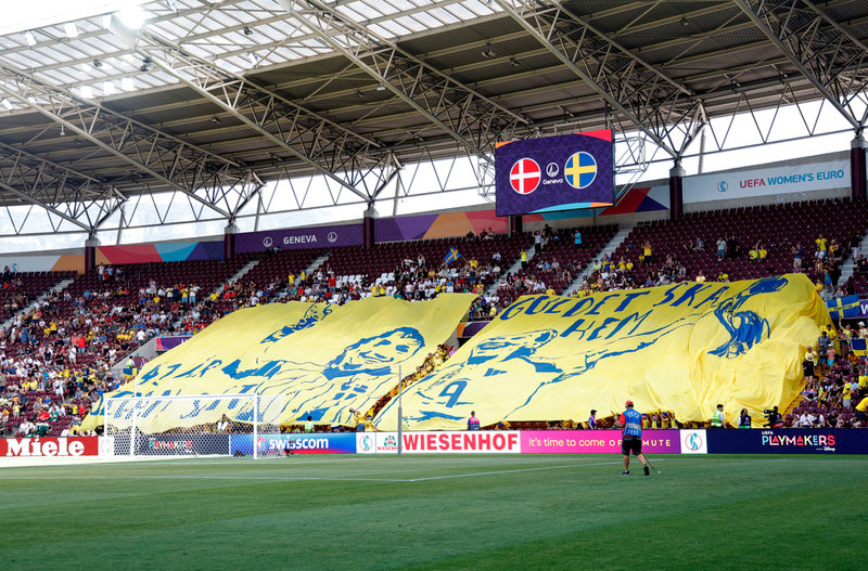"Guldet ska hem" står det på svenska tifot inför årets EM-premiär mot Danmark. Anette Börjesson och Kosovare Asllani är avbildade.