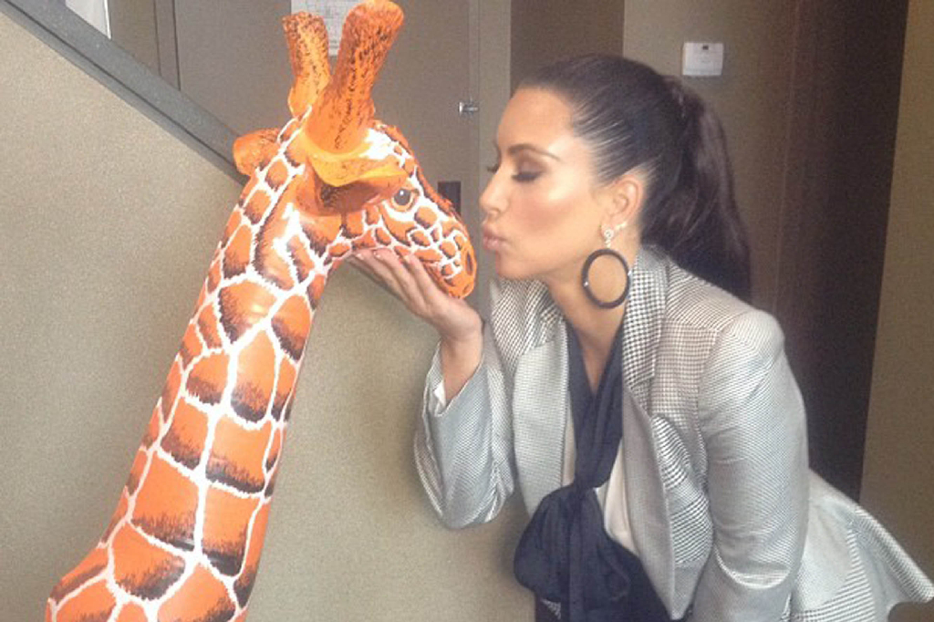 Kanye West kanske borde känna oro - hans flickvän hånglar upp en uppblåsbar giraff.