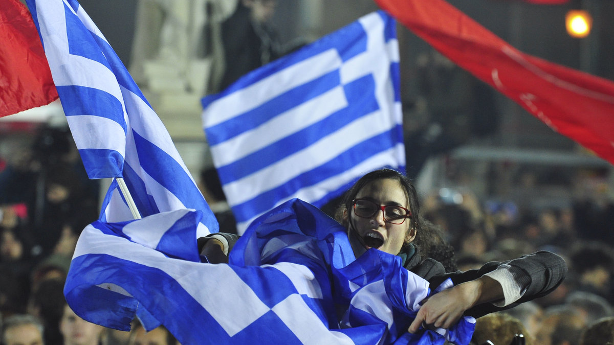 En kvinna som stöder vänsterradikala Syriza firar på Atens gator. 