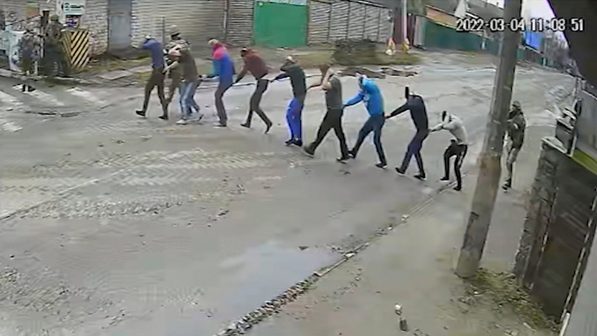 Stillbild från en övervakningskamera som visar hur tillfångatagna Butja-bor leds till ryssarnas improviserade maktbas på Jablunskagatan i Butja den 4 mars i år. De flesta kommer inte levande därifrån.