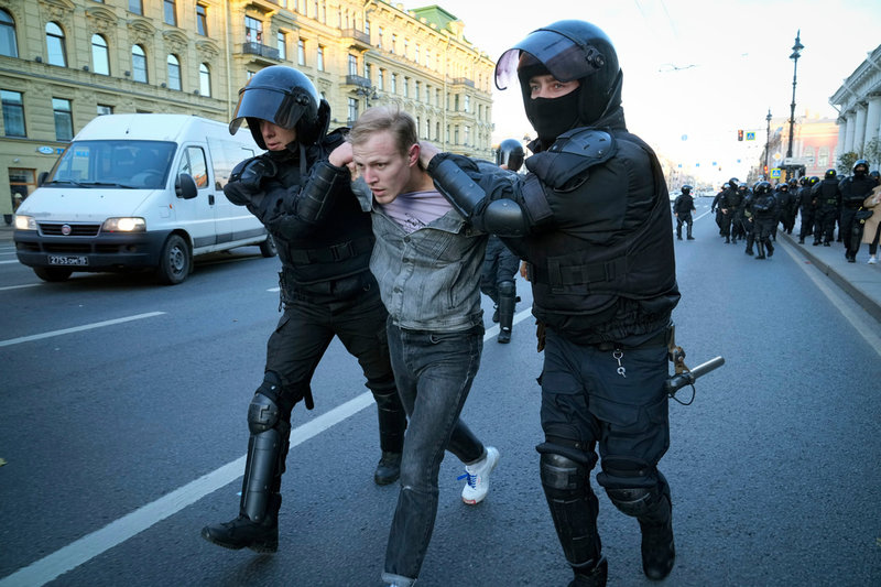 Ryska kravallpoliser för iväg en demonstrant i S:t Petersburg på lördagen.