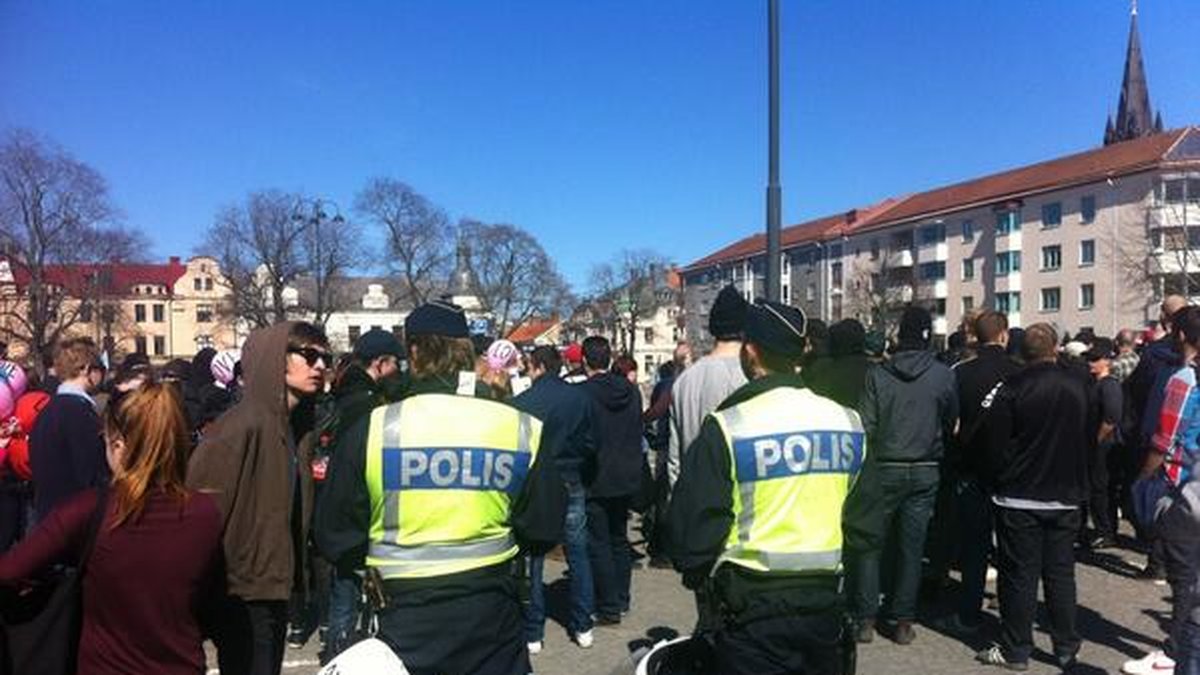Polisen bland motdemonstranter som buas och för oljud medan SvP talar.