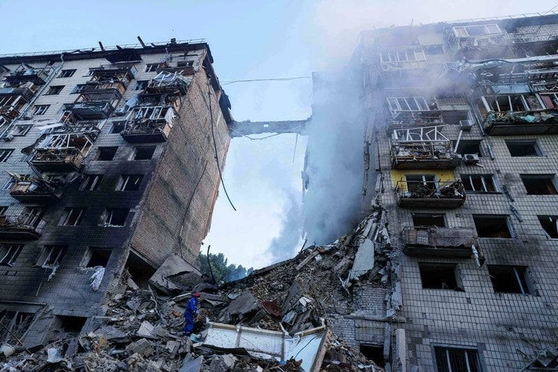 Räddningsarbetare letar efter överlevande i rasmassor i Ukrainas huvudstad Kiev tidigt på tisdagen.