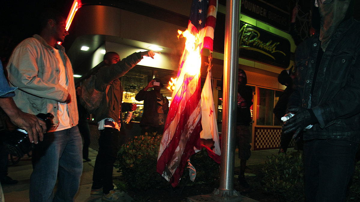 Här tänder en grupp unga eld på den amerikanska flaggan.