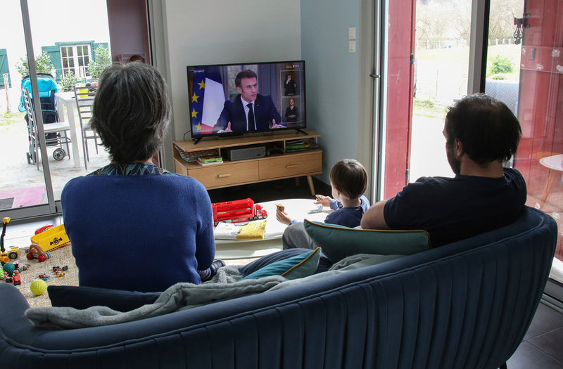 En familj i Saint-Pée-sur-Nivelle i sydvästra Frankrike lyssnar när Macron försvarar sin pensionsreform i tv.