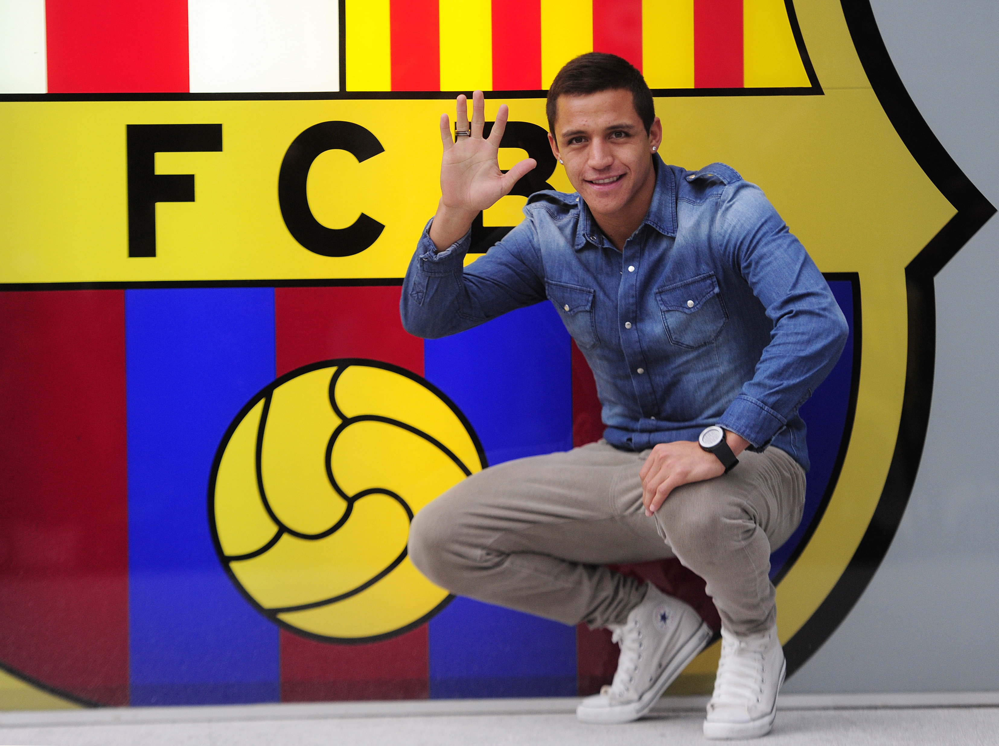 Alexis Sanchez poserar med sitt nya klubbmärke.