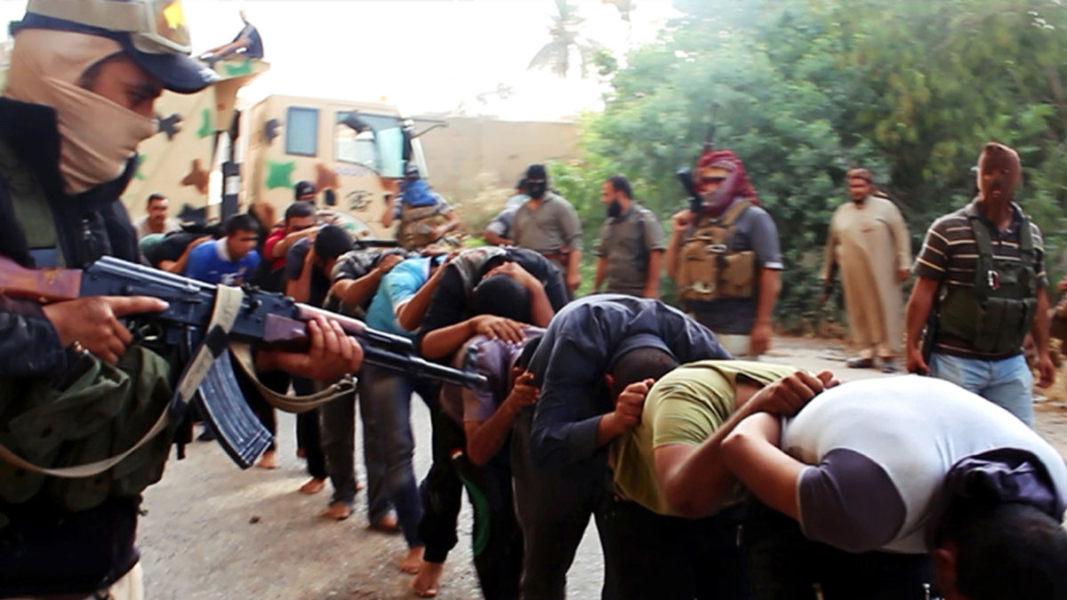 Här ses soldater från IS rikta sina vapen mot tillfångatagna irakiska soldater.
