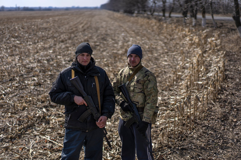 Två ukrainare står på vakt i kanten av ett vetefält i Novoselitsa i sydväst, nära den rumänska gränsen, den 17 mars.