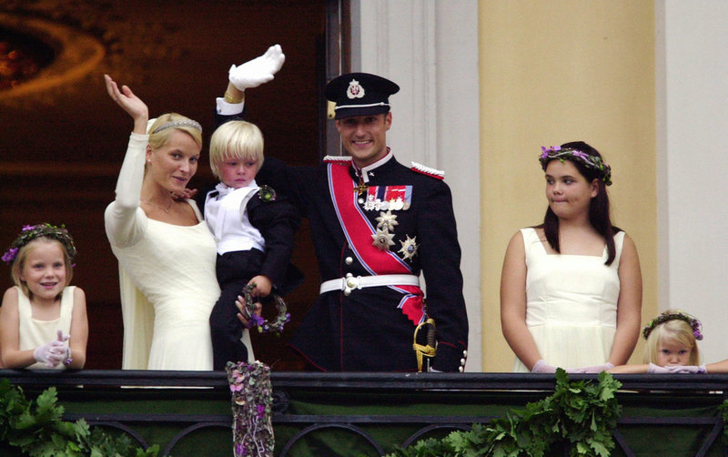 Kungligt bröllop i Oslo domkyrka i augusti 2001. Mette-Marit, som precis blivit Norges kronprinsessa, håller sin son Marius Borg Høiby i famnen när brudparet vinkar till folket.