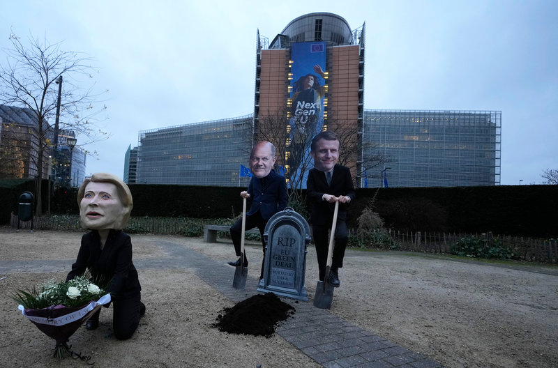 Miljöaktivister utklädda till EU-kommissionens ordförande Ursula von der Leyen, Tysklands förbundskansler Olaf Scholz och Frankrikes president Emmanuel Macron protesterar i Bryssel mot förslaget om att klassa naturgas och kärnkraft som hållbara.