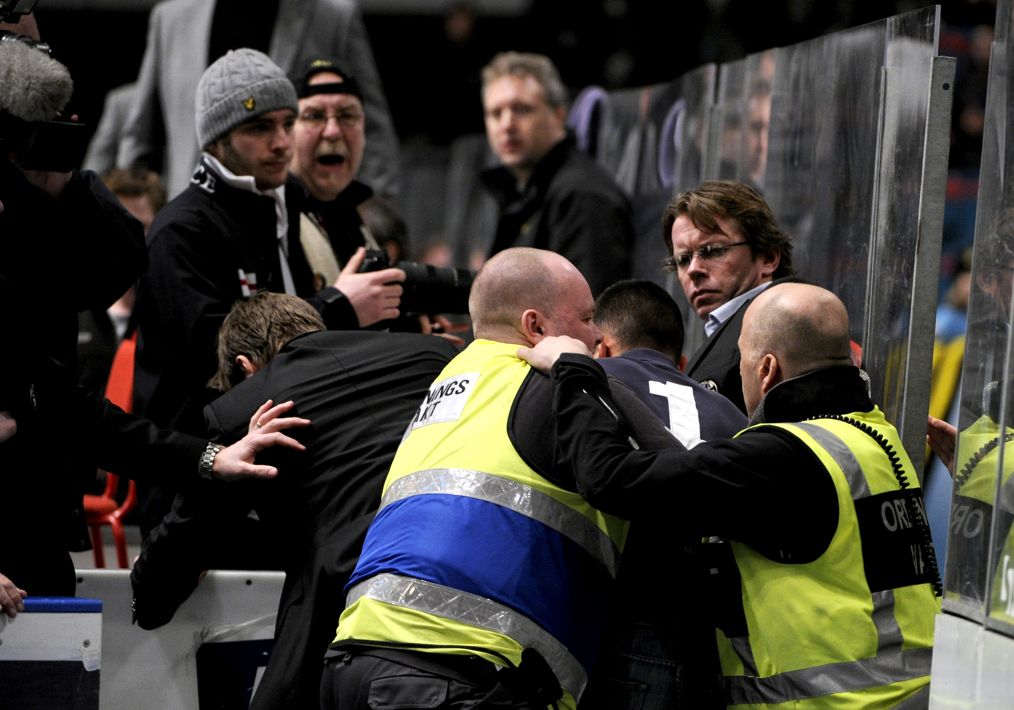 Säkerhetspersonalen stoppar fansen som försökte storma isen.