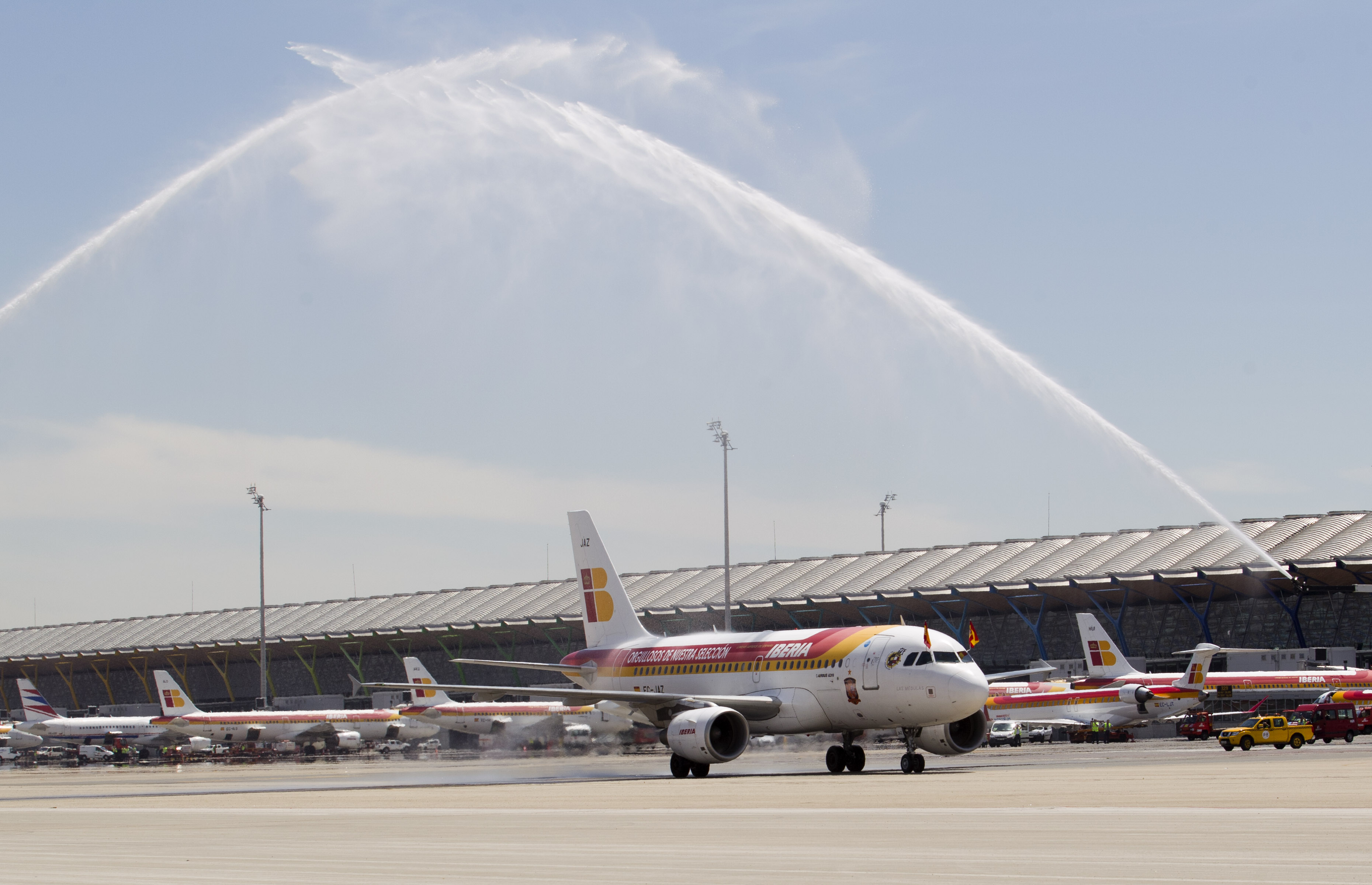 Brandbilar hyllade landslaget när de landade i Madrid genom att spruta vatten över flygplanet.