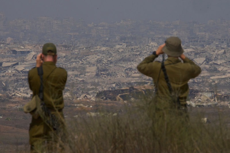 Israeliska soldater tittar på förödelsen i Gaza från södra Israel i augusti.