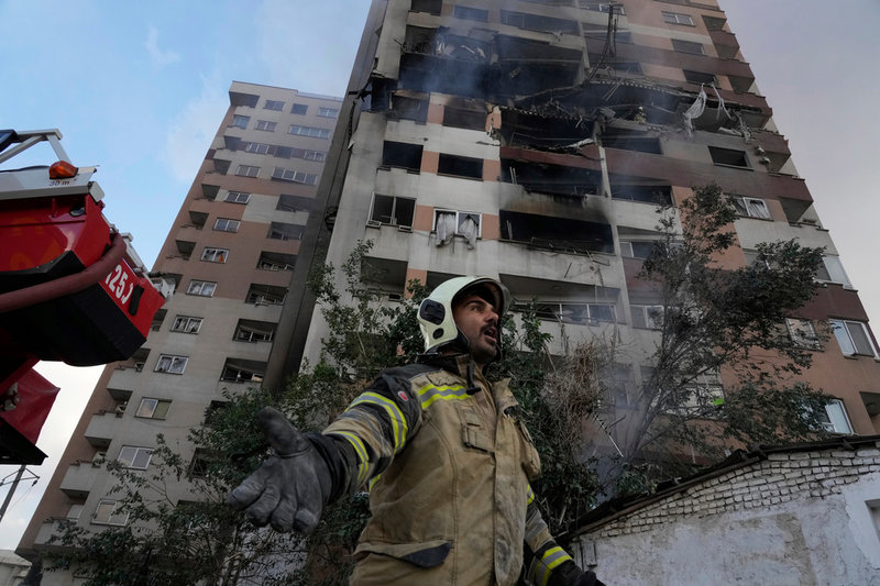 En brandman utanför ett bostadshus i Teheran efter attackerna.