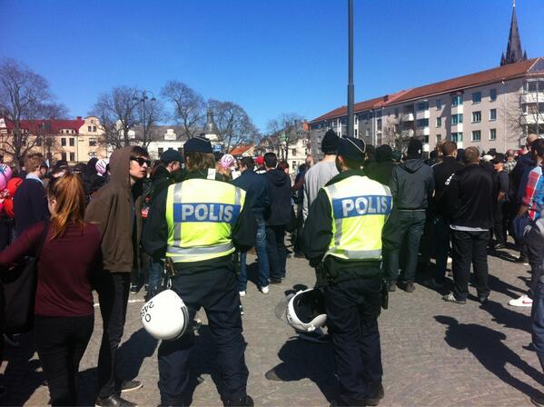 Polisen bland motdemonstranter som buas och för oljud medan SvP talar.