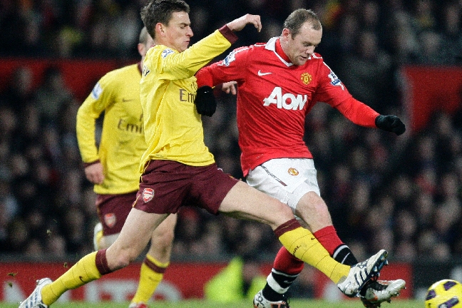 Närkamper var det gott om. Här ser vi hur Arsenals Laurent Koscielny försöker sno bollen från Wayne Rooney.