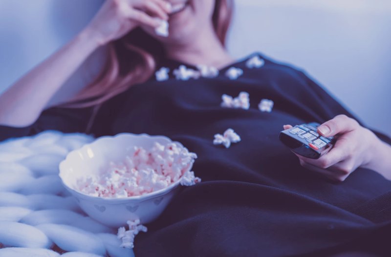 Kvinna äter popcorn Kvinna äter popcorn