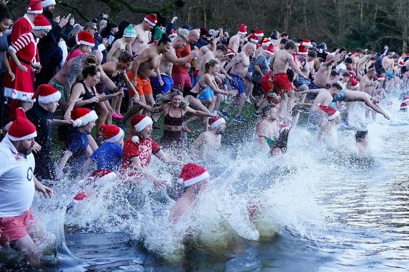 Badentusiaster deltar i det årliga juldagsdoppet i en damm i Sutton Park i Birmingham.
