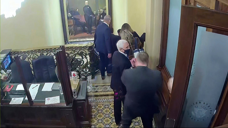 Vicepresident Mike Pence förs i säkerhet under stormningen av kongressen.