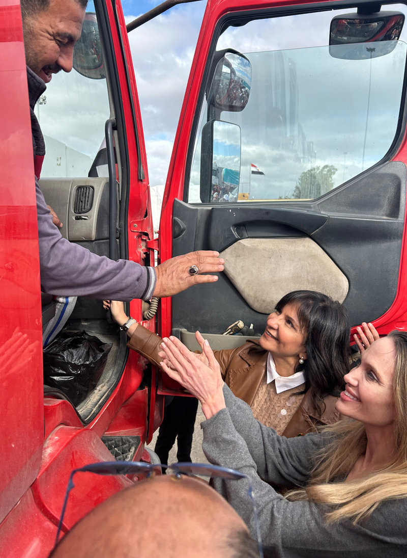 Angelina Jolie hälsar på en lastbilschaufför som väntar på att transportera in humanitärt bistånd till Gaza. 