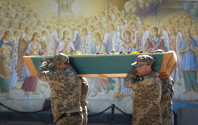 Ukrainska soldater bär en kista vid en begravning i Kiev.
