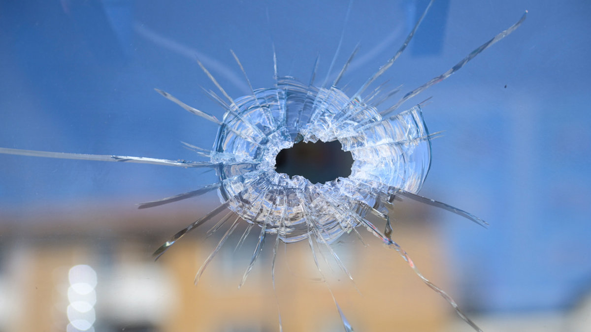 Skotthål i fönstret till grillkiosken i Rågsved där en man sköts ihjäl och ytterligare två skadades natten till torsdag.