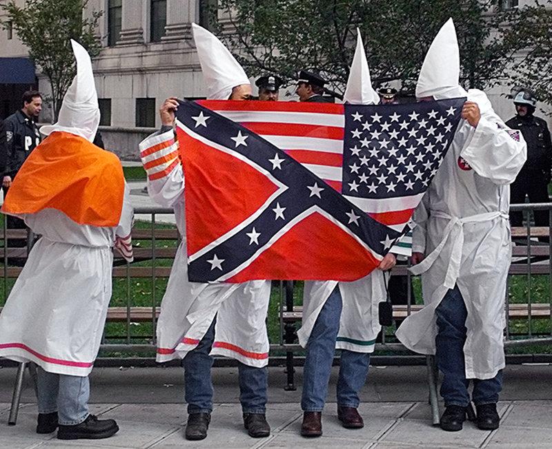 Medlemmar i Ku Klux Klan med en amerikansk flagga och en sydstatsflagga i New York 1999. Medlemmar i Ku Klux Klan med en amerikansk flagga och en sydstatsflagga i New York 1999.