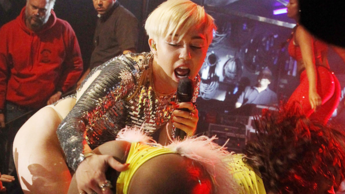 Miley och en dansös på scen. 