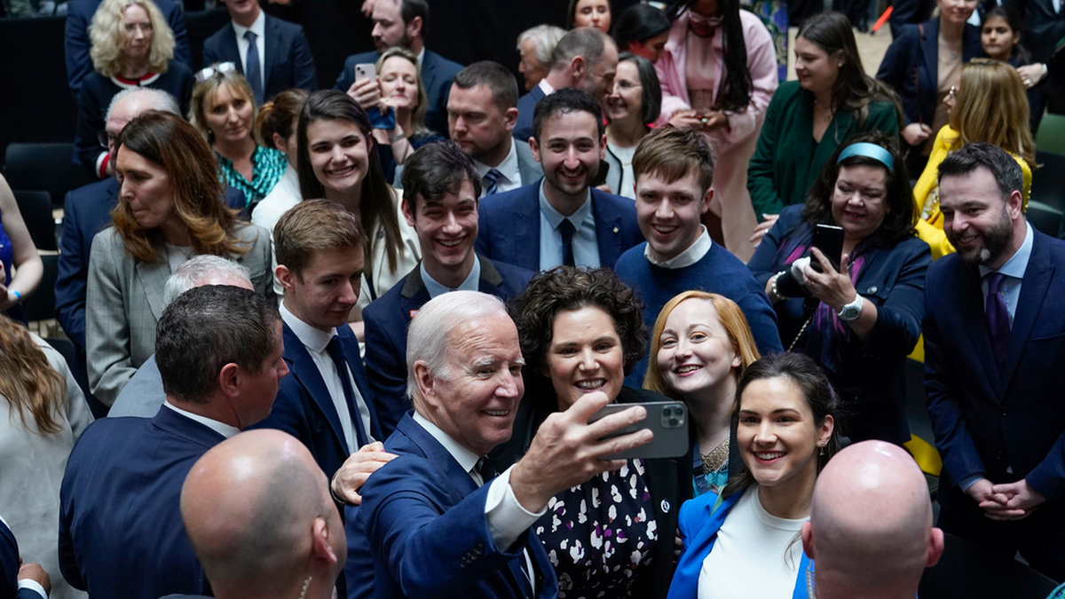 USA:s president Joe Biden tar en selfie med inbjudna gäster på Ulster University i Belfast.