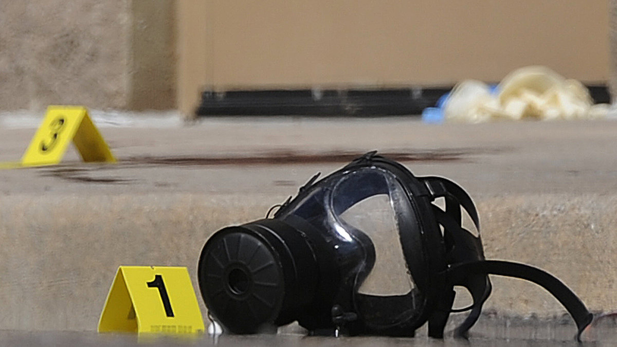 En gasmask ligger kvar på marken utanför biosalongen. Den misstänkte mördaren James Holmes tros ha använt gasmasken inne i salongen.