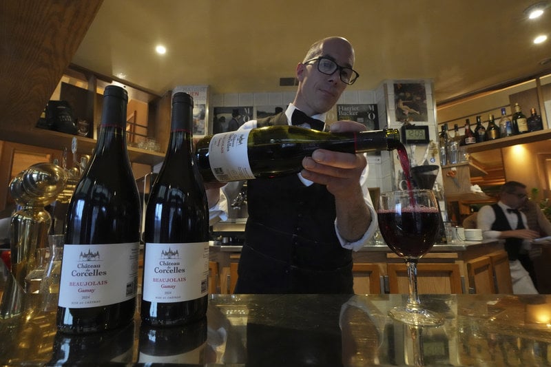 Cedric Farah häller upp ett glas Beaujolais nouveau i Paris. Foto: Michel Euler/AP/TT