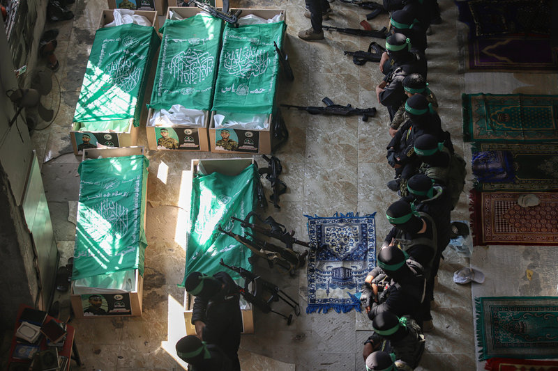Hamasmedlemmar ber invid 15 av extremiströrelsens anhängare som dödats av Israel. Bild tagen i Khan Yunis i januari i år.