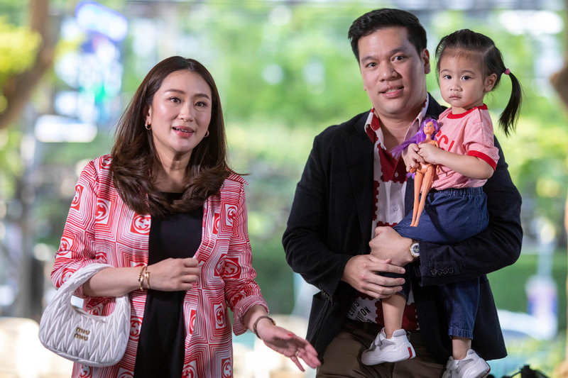 Partiet Phuea Thais partiledare Paetongtarn Shinawatra med man och barn under valdagen i huvudstaden Bangkok.