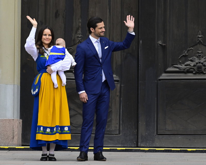 Prins Carl Philip och prinsessan Sofia, med prinsessan Ines i famnen, öppnar Kungliga slottets södra portar och välkomnar allmänheten till nationaldagsfirande.