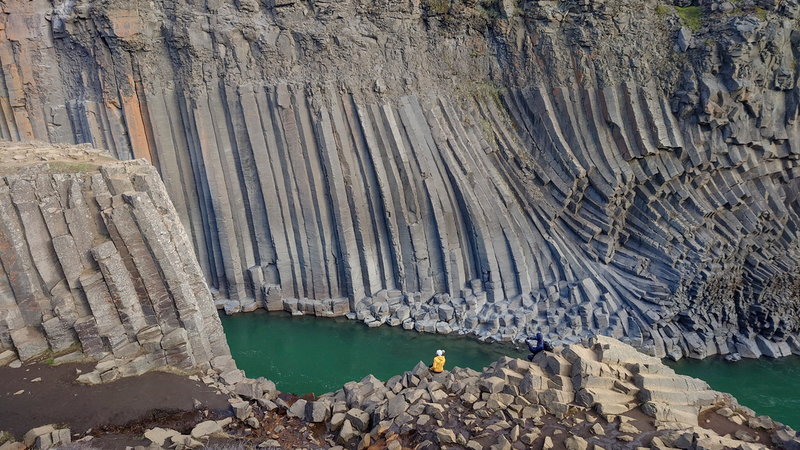 Islands dramatiska natur lockar många. Här sitter en turist på klippkanten i lavaravinen Studlagil.