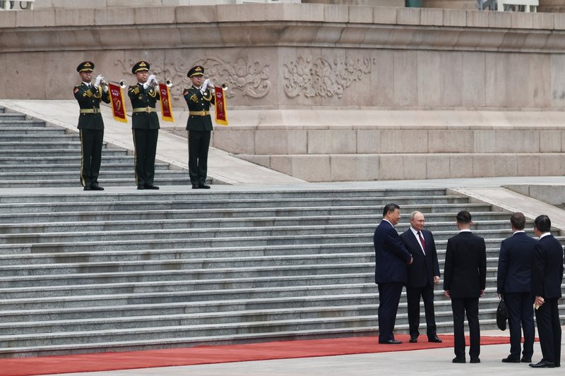 Vladimir Putin och Xi Jinping skakar hand utanför Folkets stora sal i Peking.