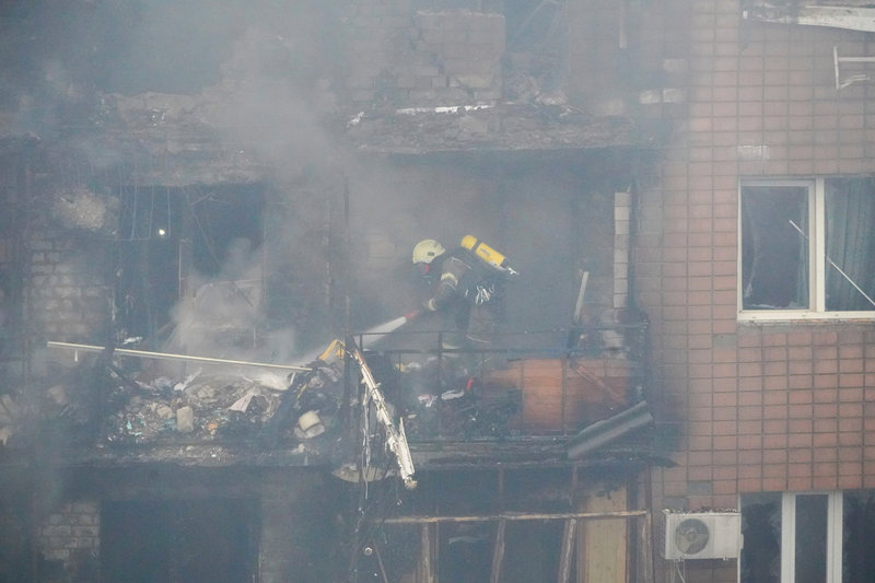 Brandmän i arbete i det flerfamiljshus som bombades i Charkiv.
