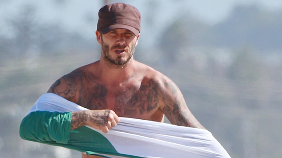 Beckham drar på sig en tröja. 
